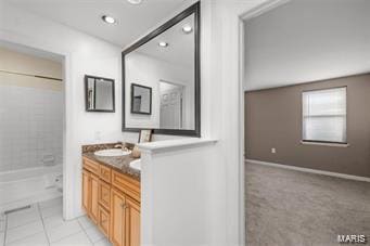 bathroom featuring tile patterned floors, vanity, and tiled shower / bath combo