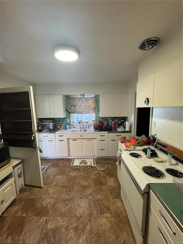 kitchen featuring sink, white electric stove, tasteful backsplash, and white cabinetry