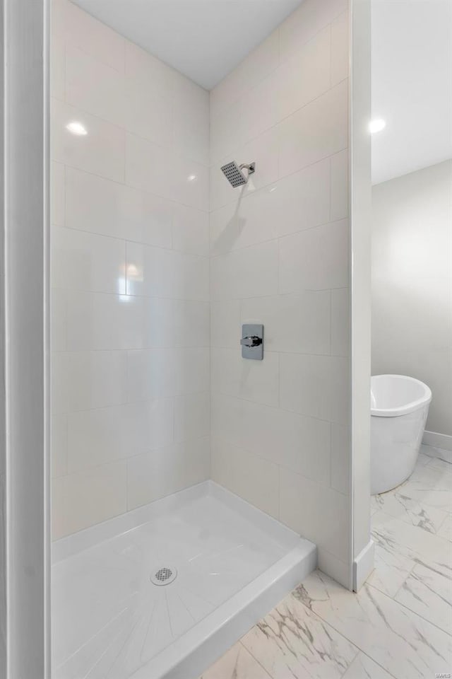 full bathroom with marble finish floor, a shower stall, and baseboards