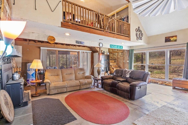 living room featuring high vaulted ceiling and concrete flooring