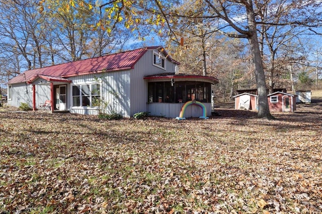 view of side of home with a storage shed and a sunroom