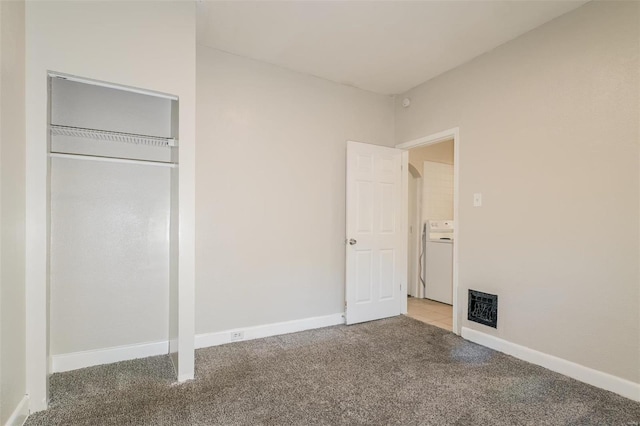 unfurnished bedroom featuring carpet flooring, a closet, and washer / clothes dryer