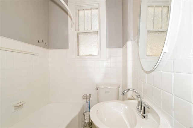 full bathroom with toilet,  shower combination, tile walls, and sink