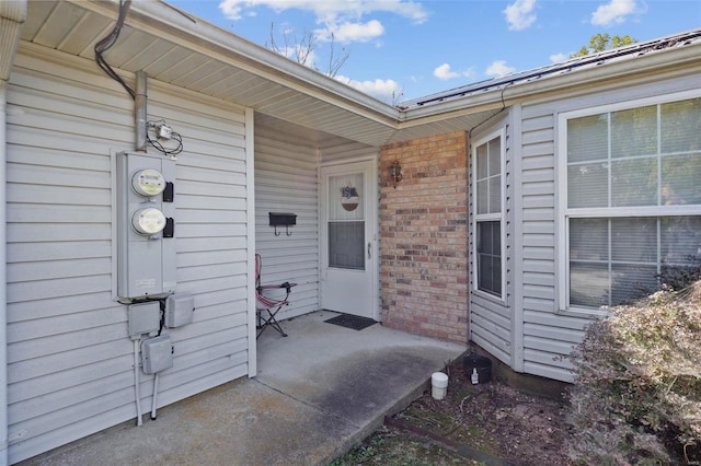 view of exterior entry with a patio area