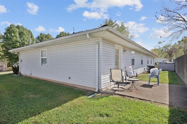 view of property exterior featuring a patio and a lawn