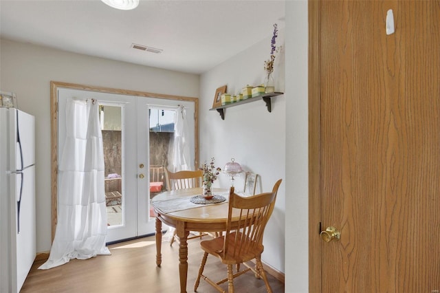 dining space featuring french doors and light hardwood / wood-style flooring