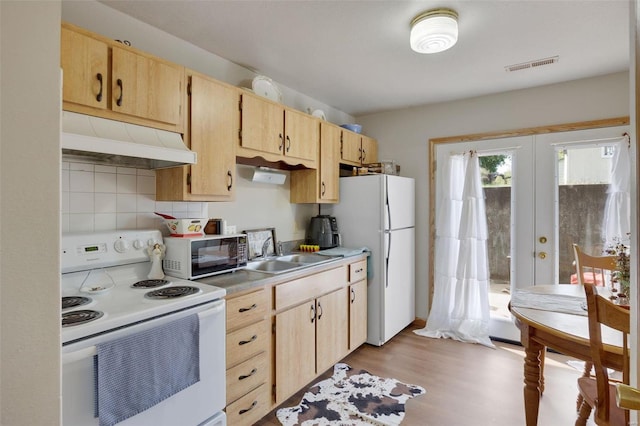 kitchen featuring light wood-type flooring, decorative backsplash, white appliances, sink, and light brown cabinetry