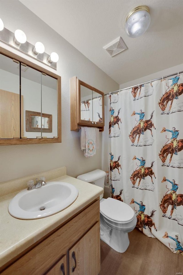 bathroom with a shower with shower curtain, vanity, and toilet