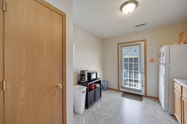 kitchen featuring white refrigerator and light brown cabinets