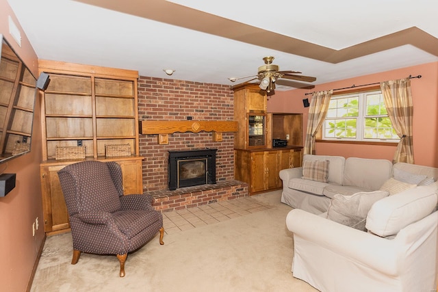 living room featuring a fireplace, light colored carpet, and ceiling fan