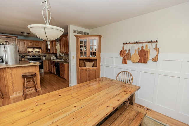 dining space with wood-type flooring and sink