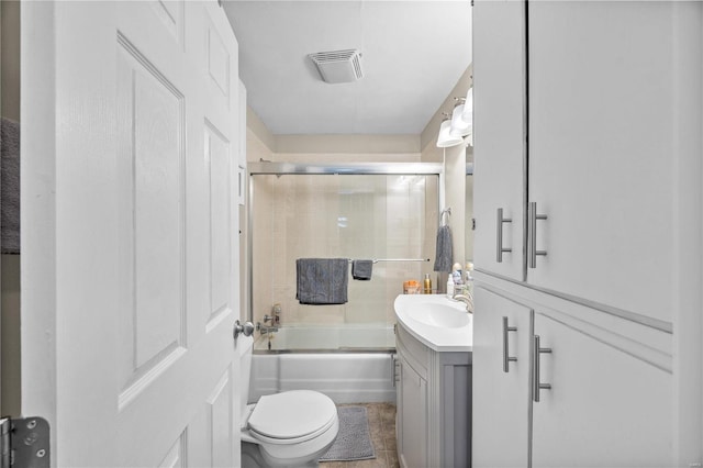 full bathroom featuring shower / bath combination with glass door, vanity, toilet, and tile patterned floors