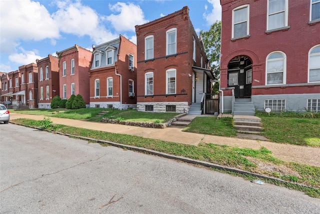 townhome / multi-family property with brick siding and a residential view