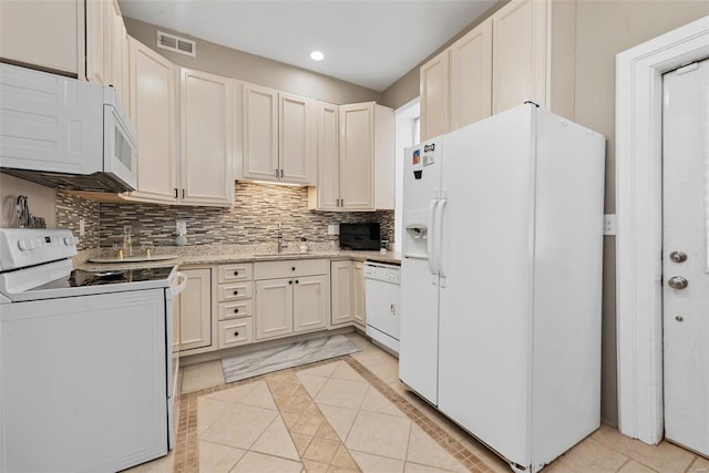 kitchen featuring light tile patterned floors, white appliances, a sink, visible vents, and tasteful backsplash