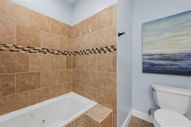 bathroom with a whirlpool tub, tile patterned flooring, toilet, and baseboards