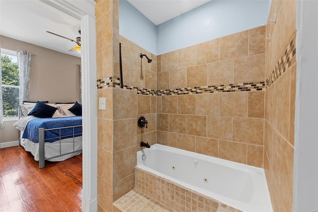 full bath featuring a combined bath / shower with jetted tub, a ceiling fan, hardwood / wood-style floors, and ensuite bathroom