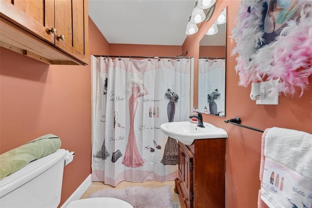 bathroom featuring toilet, baseboards, a shower with shower curtain, and vanity