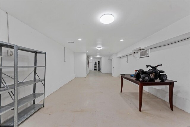 finished basement featuring a wall mounted AC and recessed lighting