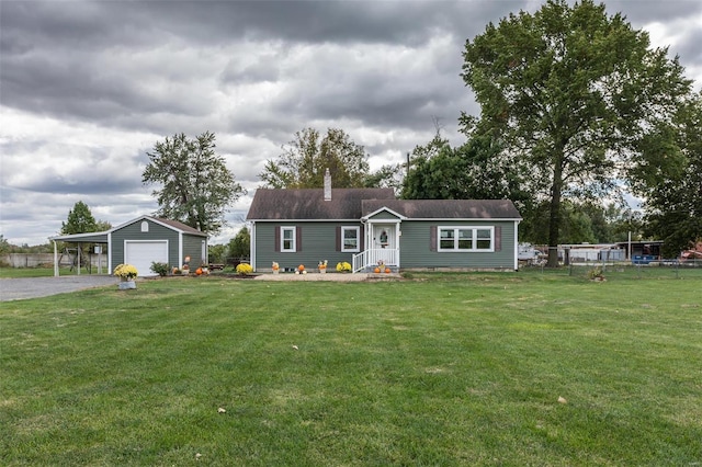 view of front of property featuring a front lawn, an outbuilding, a garage, and a carport