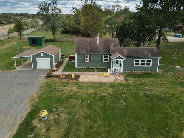 view of front of property with a storage shed, a front lawn, and a garage