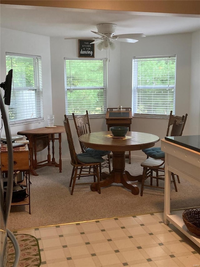 dining area featuring light colored carpet and ceiling fan