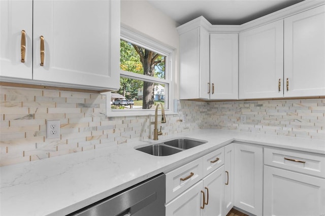 kitchen featuring white cabinets, light stone countertops, sink, and decorative backsplash