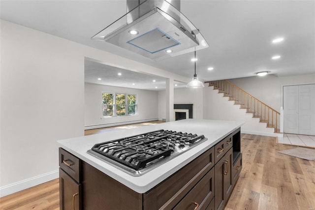 kitchen featuring a center island, pendant lighting, stainless steel gas stovetop, light hardwood / wood-style flooring, and dark brown cabinets