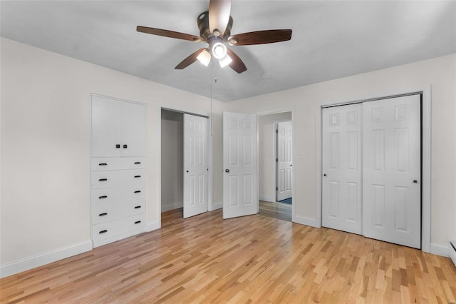 unfurnished bedroom featuring ceiling fan, multiple closets, and light hardwood / wood-style floors