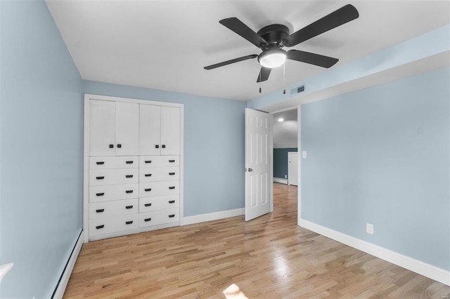 unfurnished bedroom with a baseboard heating unit, ceiling fan, a closet, and light hardwood / wood-style floors