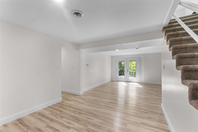 unfurnished room with light wood-type flooring and french doors