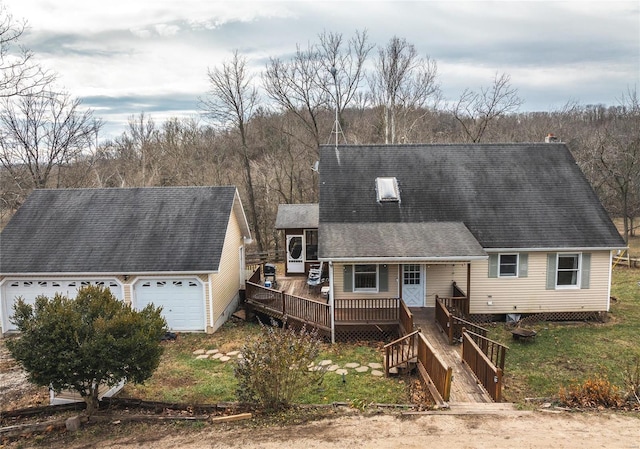 cape cod-style house with a garage, a shingled roof, and a wooden deck