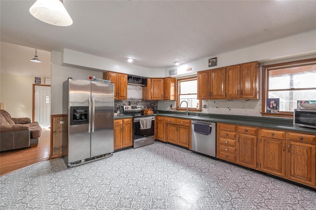 kitchen featuring pendant lighting, sink, appliances with stainless steel finishes, and a textured ceiling