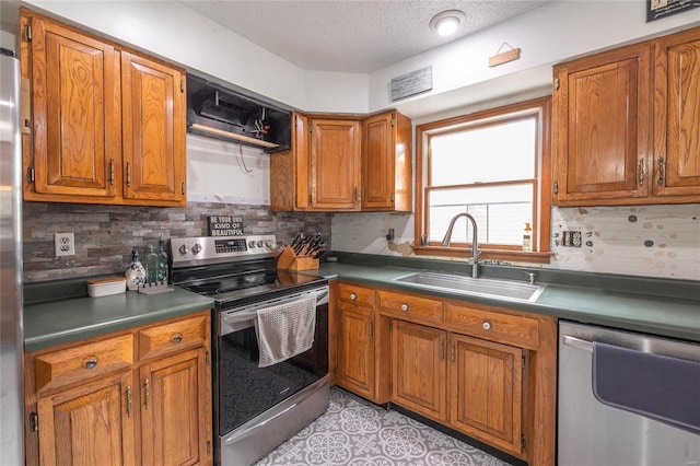 kitchen with backsplash, a textured ceiling, stainless steel appliances, sink, and light tile patterned floors