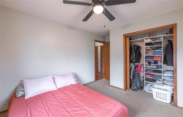 carpeted bedroom featuring ceiling fan and a closet