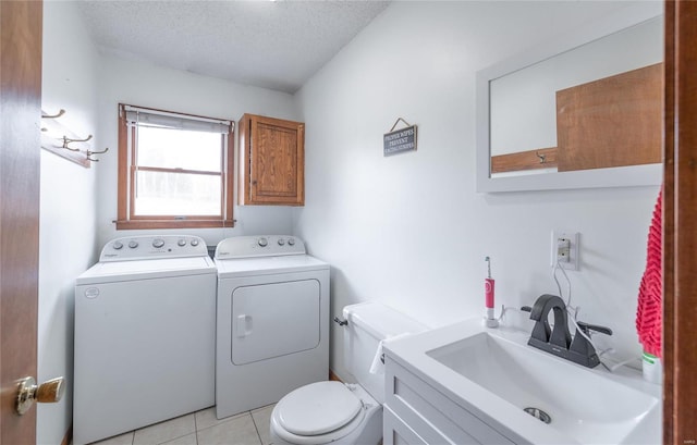 bathroom featuring washing machine and clothes dryer, tile patterned flooring, a textured ceiling, toilet, and vanity