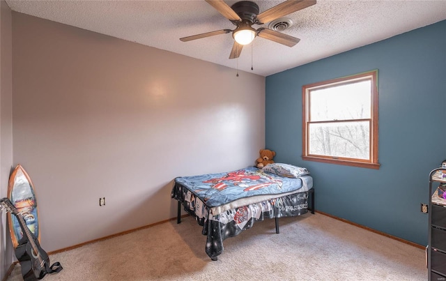 carpeted bedroom featuring ceiling fan and a textured ceiling