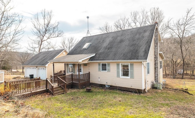 back of property with a porch, a garage, a yard, and central AC