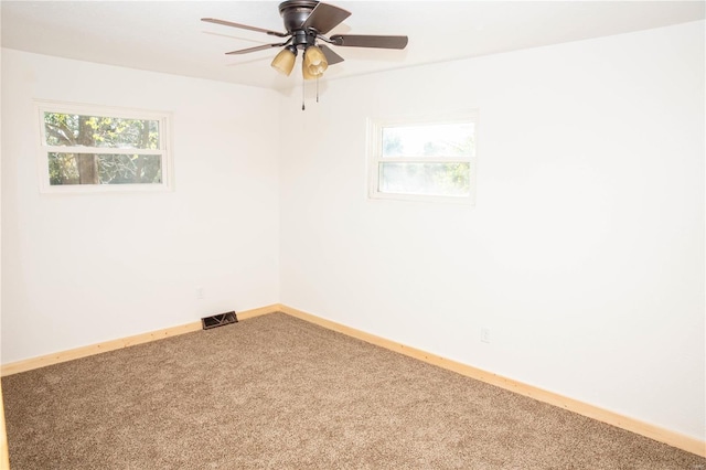 unfurnished room featuring ceiling fan, plenty of natural light, and carpet