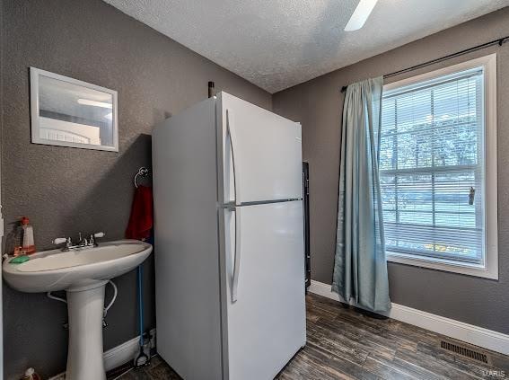 bathroom featuring wood-type flooring and a textured ceiling