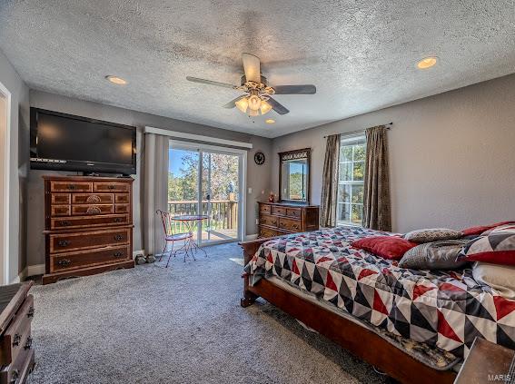 carpeted bedroom with access to exterior, multiple windows, ceiling fan, and a textured ceiling