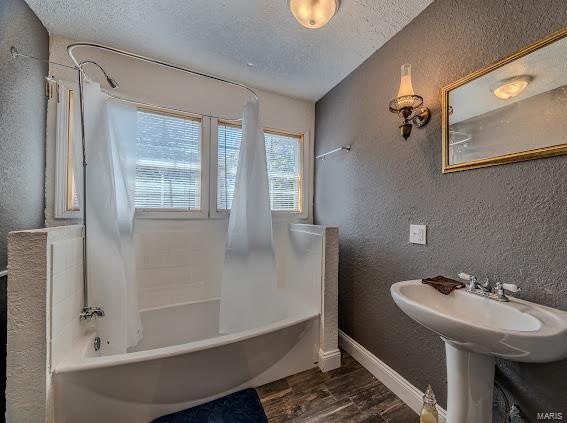 bathroom featuring shower / bath combo, a textured ceiling, and hardwood / wood-style flooring