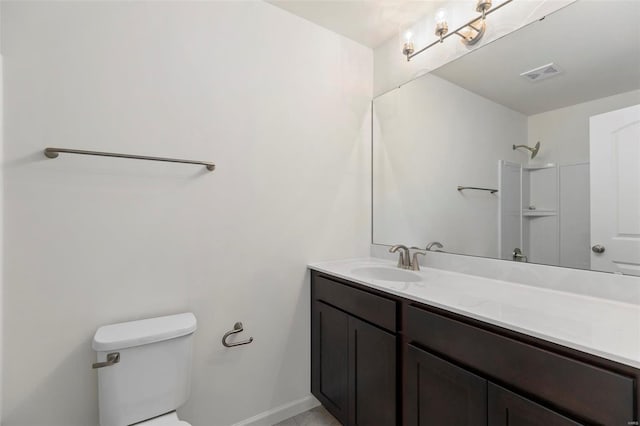 bathroom with a shower, vanity, and toilet