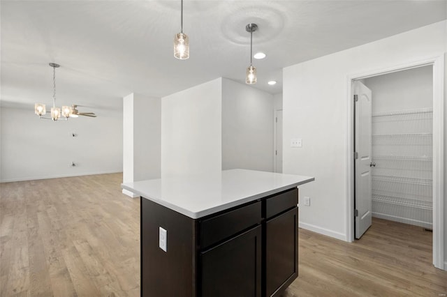 kitchen featuring hanging light fixtures, a kitchen island, and light hardwood / wood-style flooring