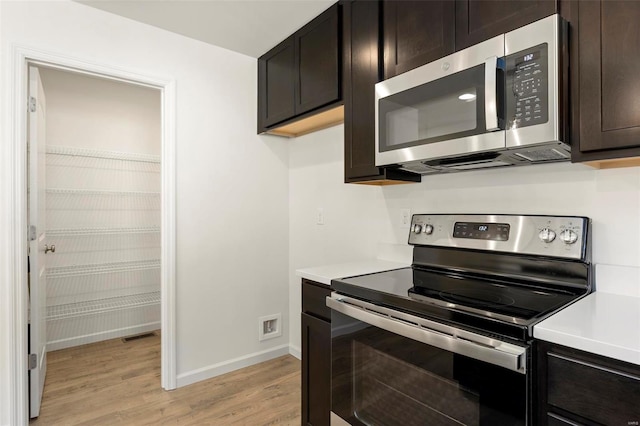 kitchen featuring dark brown cabinets, stainless steel appliances, and light hardwood / wood-style flooring