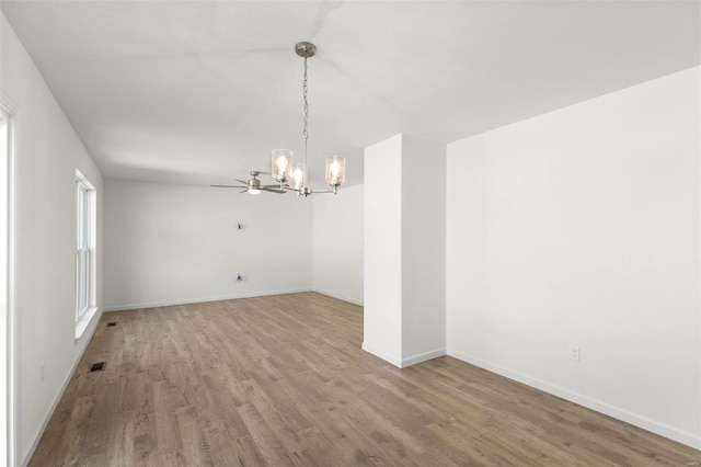 empty room featuring hardwood / wood-style floors and an inviting chandelier