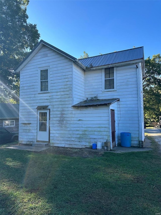 rear view of property with a lawn