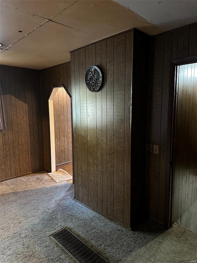 corridor with carpet floors and wood walls