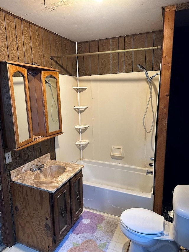 full bathroom with bathtub / shower combination, vanity, toilet, and wooden walls