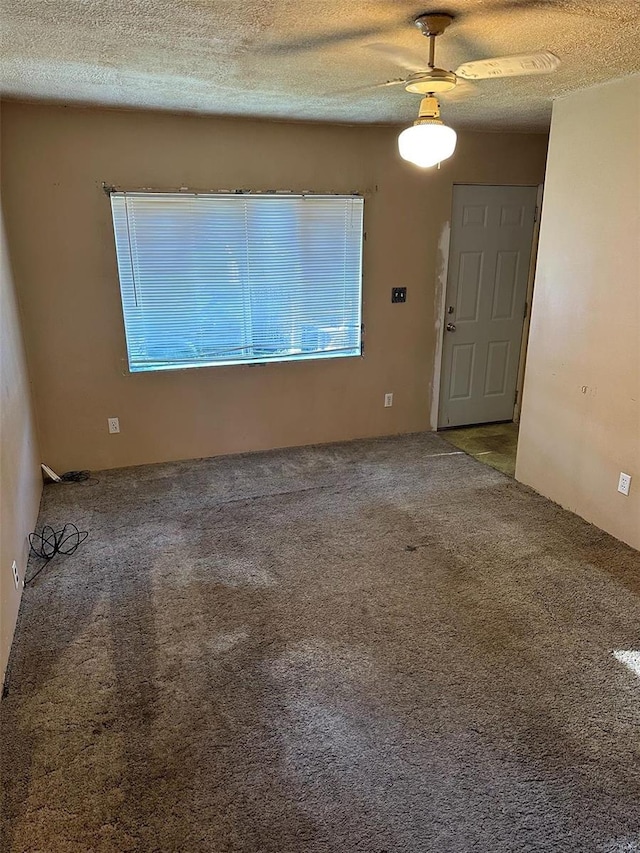 carpeted empty room featuring a textured ceiling and ceiling fan