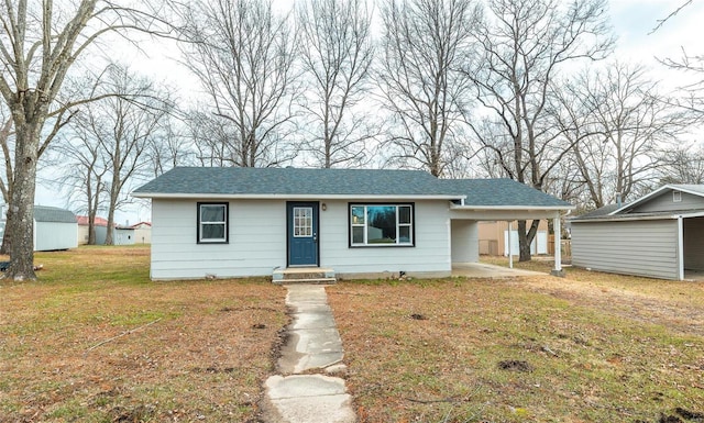 view of front of property featuring a front yard and a carport